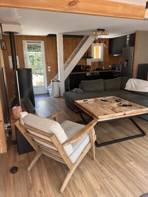 A modern living room with a wooden floor, a sofa, a coffee table, and a TV.