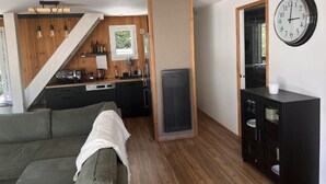 A compact living space with a kitchen area, a dining table, and a sofa.