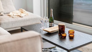 Ein modernes Wohnzimmer mit einer Couch, einem Couchtisch und einer Champagnerflasche.