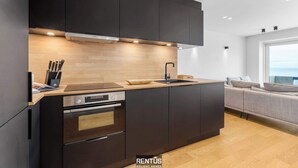 Eine moderne Küche mit dunklen Schränken, einer Holz Arbeitsplatte und integrierten Geräten.