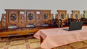 A traditional wooden table with a laptop on it, set on a patterned carpet. - Hotel O Guest House Pak Darso (Kalijambe)