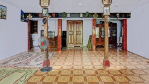 A room with patterned floor tiles, a wooden door, and a fan. - Hotel O Guest House Pak Darso (Kalijambe)