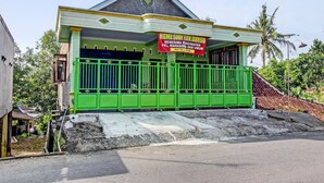 A building with a green exterior and a signboard advertising "HOME STAY PAK DARSO". - Hotel O Guest House Pak Darso (Kalijambe)