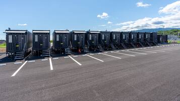 Portable restrooms lined up in a parking lot with clear markings.