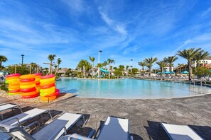 A swimming pool with lounge chairs and palm trees.