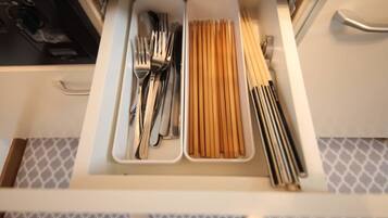 A drawer with utensils and chopsticks.