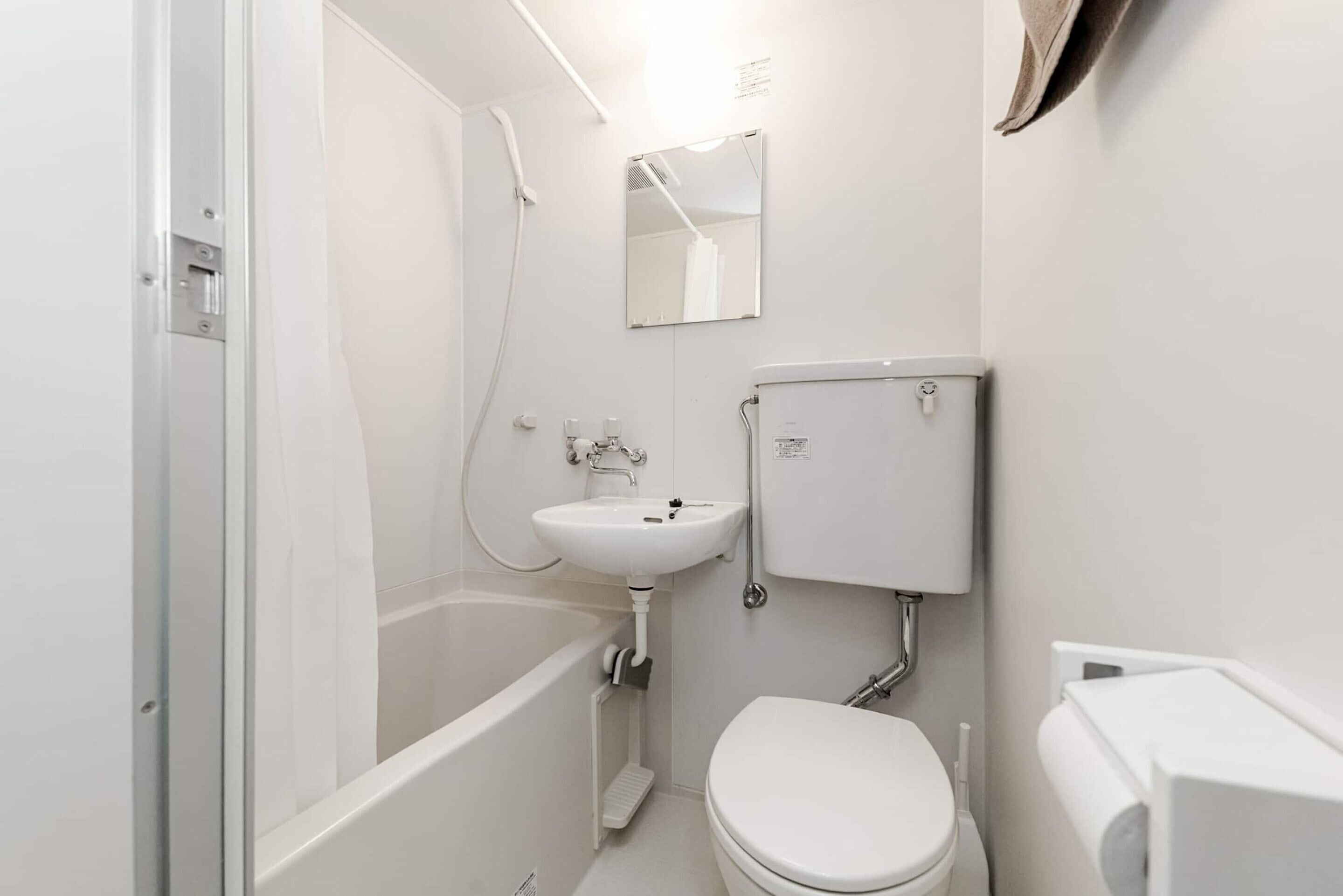 Un baño con bañera, inodoro, lavabo y espejo.