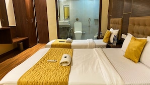 A hotel room with two beds, a bathroom visible through a glass door, and wooden flooring. - Hotel Pearls BKC Inn (Mumbai)