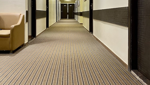 A hotel hallway with a striped carpet, beige walls, and doors numbered 806 and 807. - Hotel Pearls BKC Inn (Mumbai)