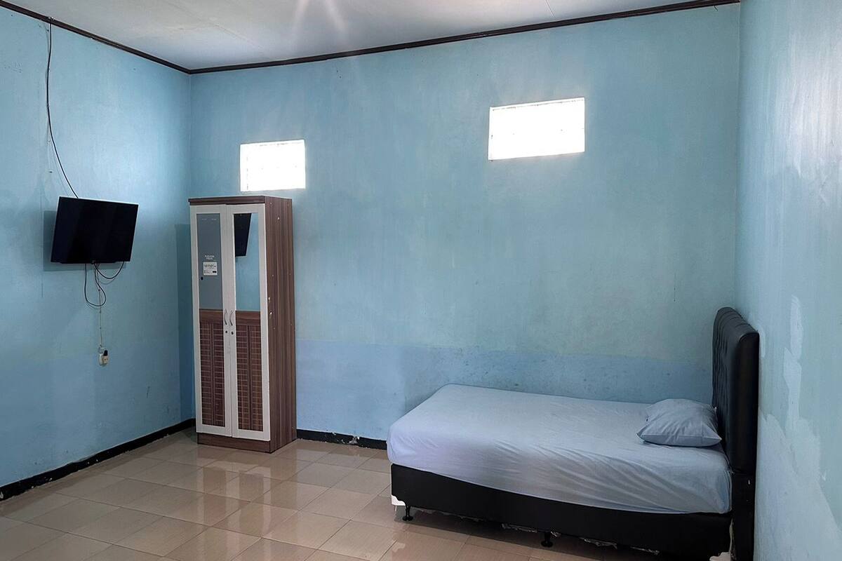 A room with a bed, a wardrobe, and a television.
