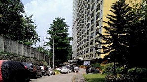 A multi-story residential building with a parking lot in front.