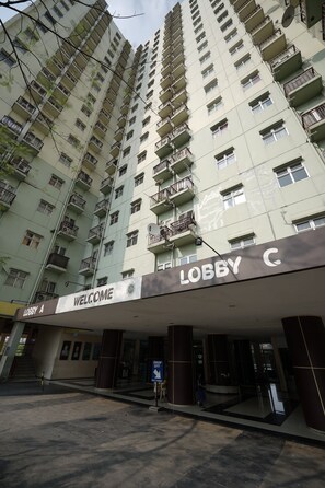 A high-rise building with multiple balconies and a sign reading "WELCOME LOBBY C". - Perfect Stay Apartement The Suites Metro Bandung By Sultan Property (Bandung)