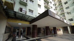 A hotel lobby with a large entrance, a reception desk, and a staircase leading to the upper floors. - Perfect Stay Apartement The Suites Metro Bandung By Sultan Property (Bandung)