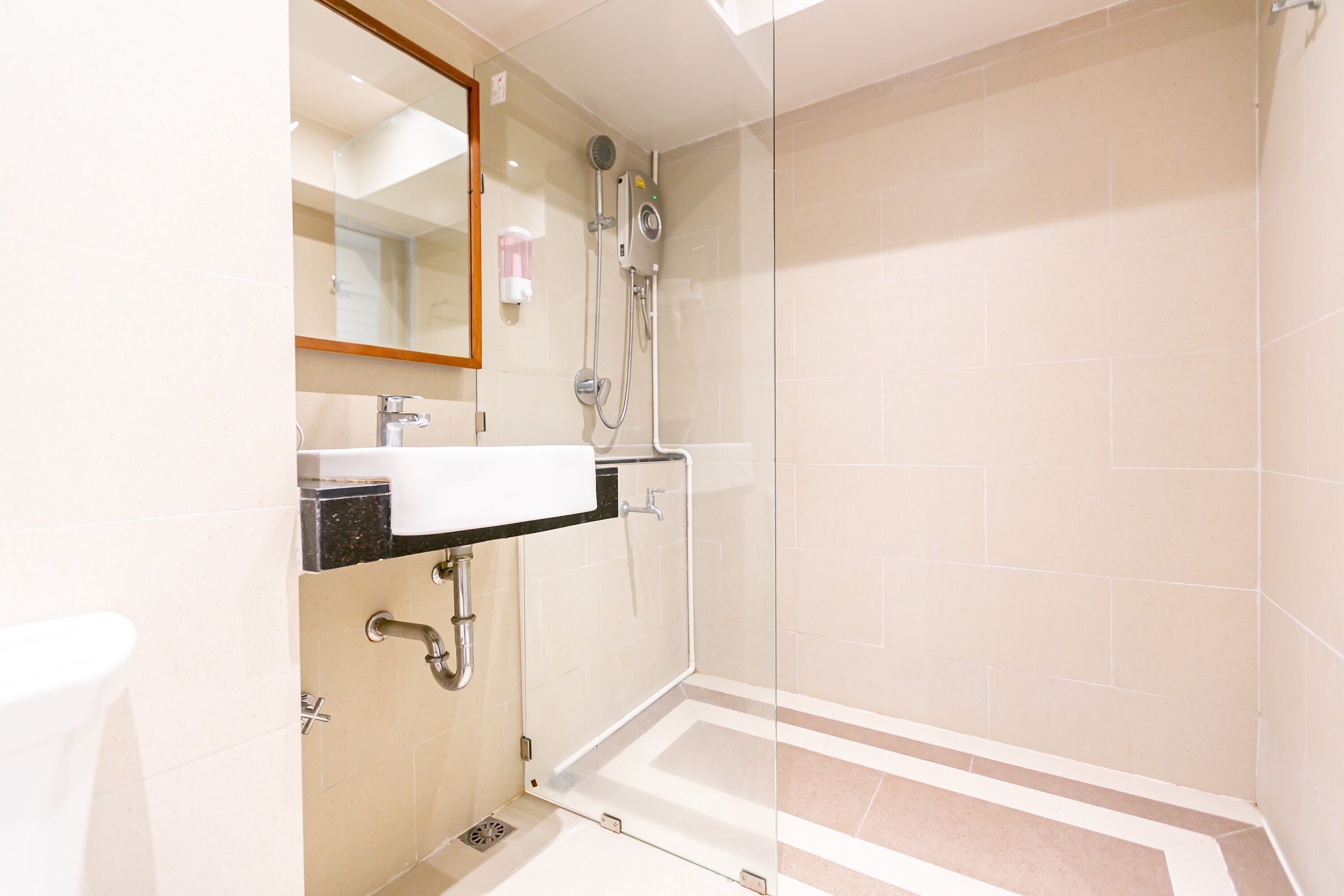 A modern bathroom with a glass shower enclosure, a sink with a mirror, and a toilet.