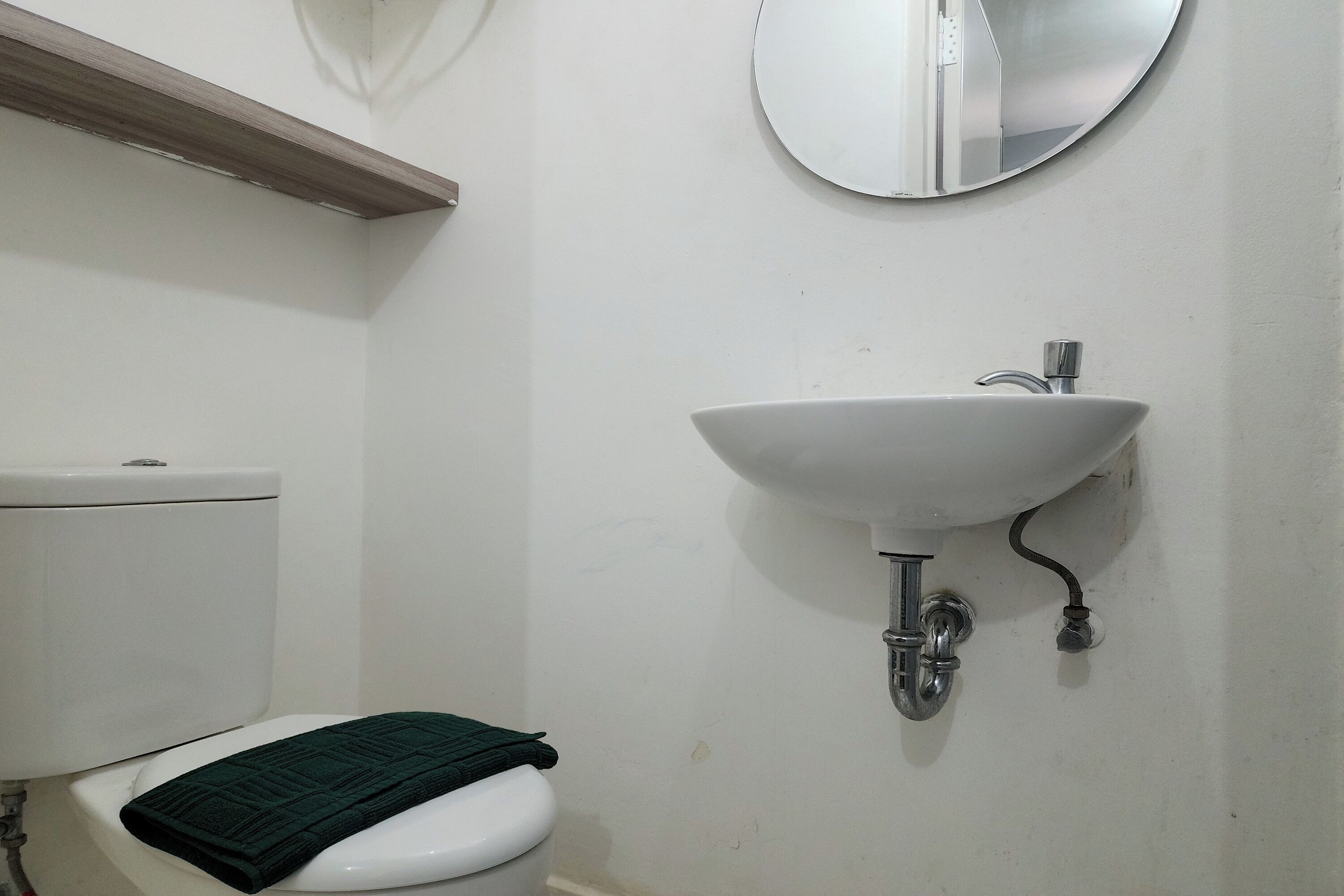 Une salle de bain avec des toilettes, un lavabo et un miroir.