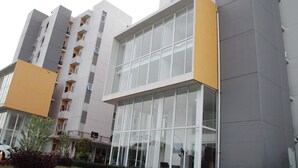 A multi-story building with a modern architectural design, featuring large windows and balconies.