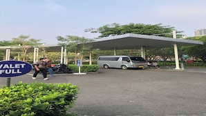 A parking area with a covered structure, a sign indicating 'VALET FULL', and a van parked under the canopy. - Heritage Home (Gading Serpong)