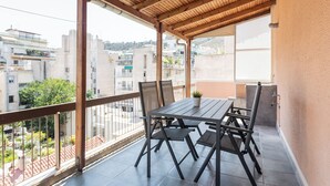 A balcony with a wooden pergola, a table, and four chairs. - Harmonious 2BR Apartment in Exarchia (Athens)