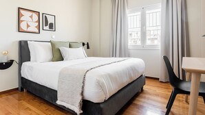 A neatly arranged bedroom with a bed, bedside table, and a window with curtains. - Harmonious 2BR Apartment in Exarchia (Athens)