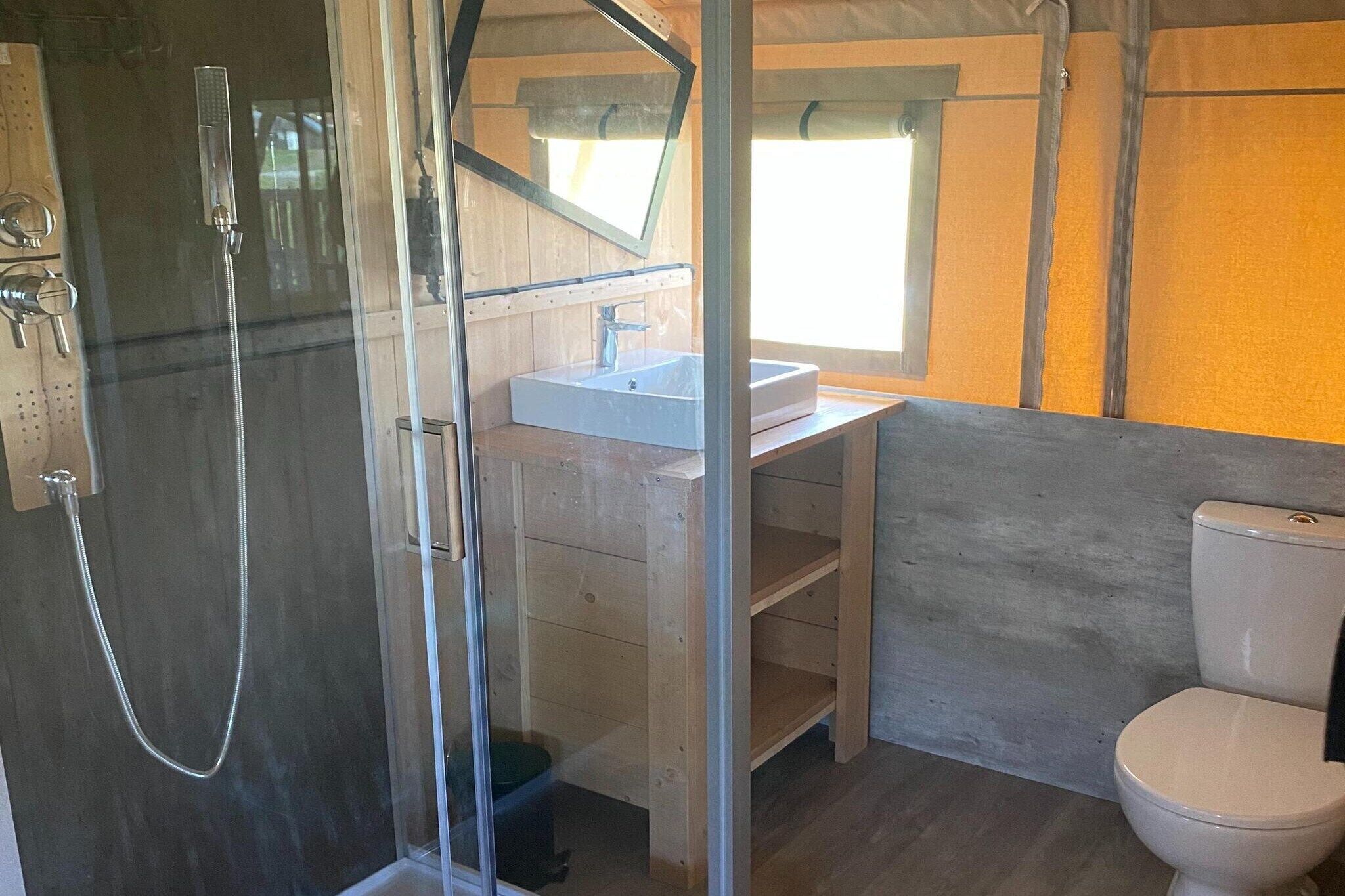 Une salle de bain avec une douche à parois de verre, un lavabo et des toilettes.