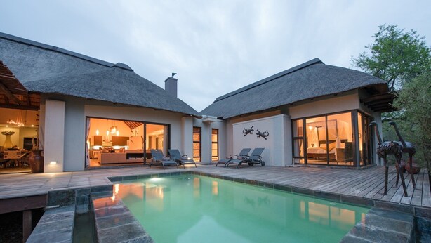 A modern villa with a swimming pool, two large rooms with glass doors, and a thatched roof. - Luxury villa with a swimming pool in Hoedspruit (Hoedspruit)