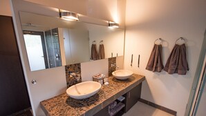 A bathroom with two sinks, a large mirror, and towels hanging on hooks. - Luxury villa with a swimming pool in Hoedspruit (Hoedspruit)