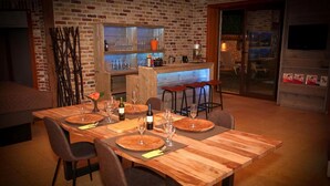 A dining area with a brick wall, wooden table, and bar counter. - Villa with swimming pool in Erembodegem (Erembodegem)