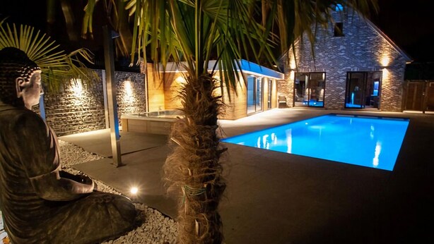 A stone building with a swimming pool at night. - Villa with swimming pool in Erembodegem (Erembodegem)