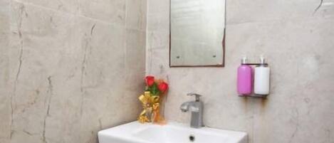 A bathroom with a white sink, a mirror, and a towel rack.