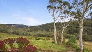 A rural landscape with a grassy field, trees, and a distant mountain range. - Bella Vista Valley Views (BLACKHEATH)
