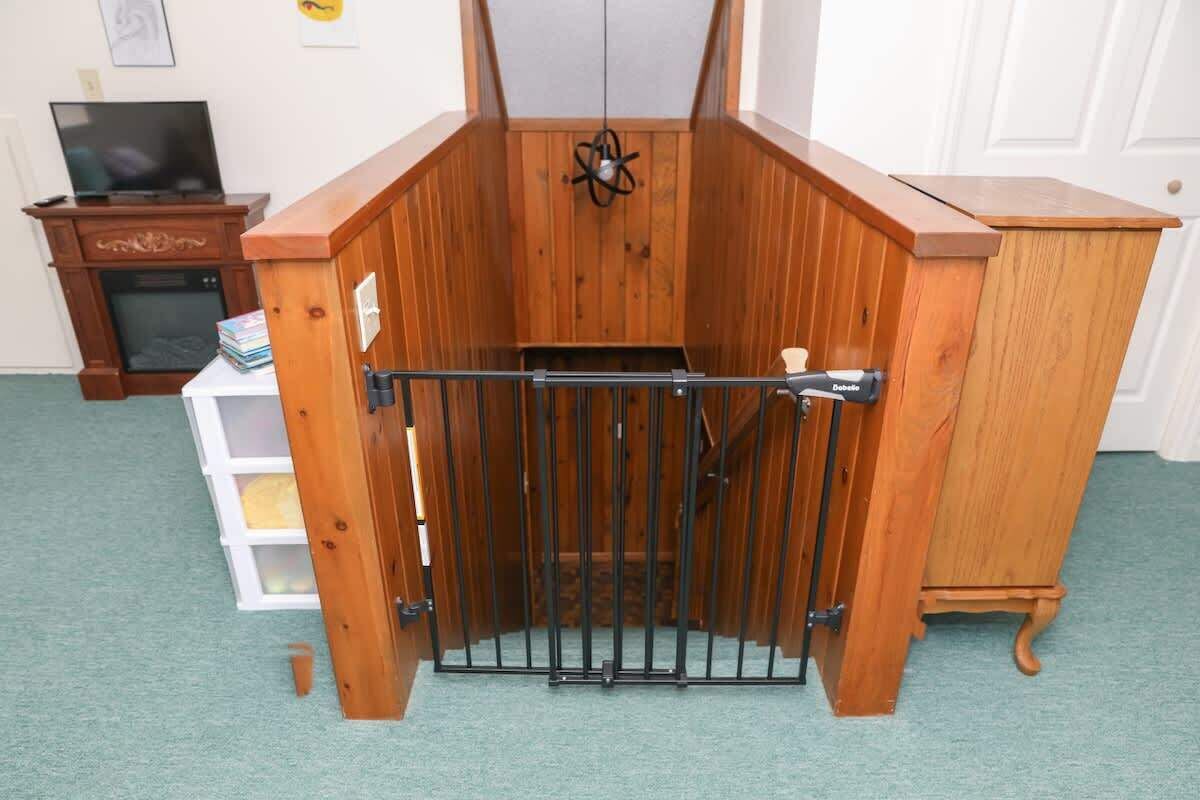 Ein Zimmer mit Holzboden, einem Tor, einem Fernseher und einem weißen Schrank.