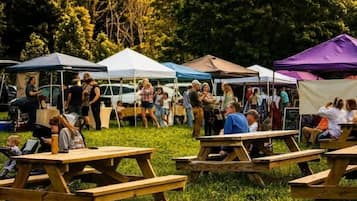 An outdoor event with people gathered around tables and tents.