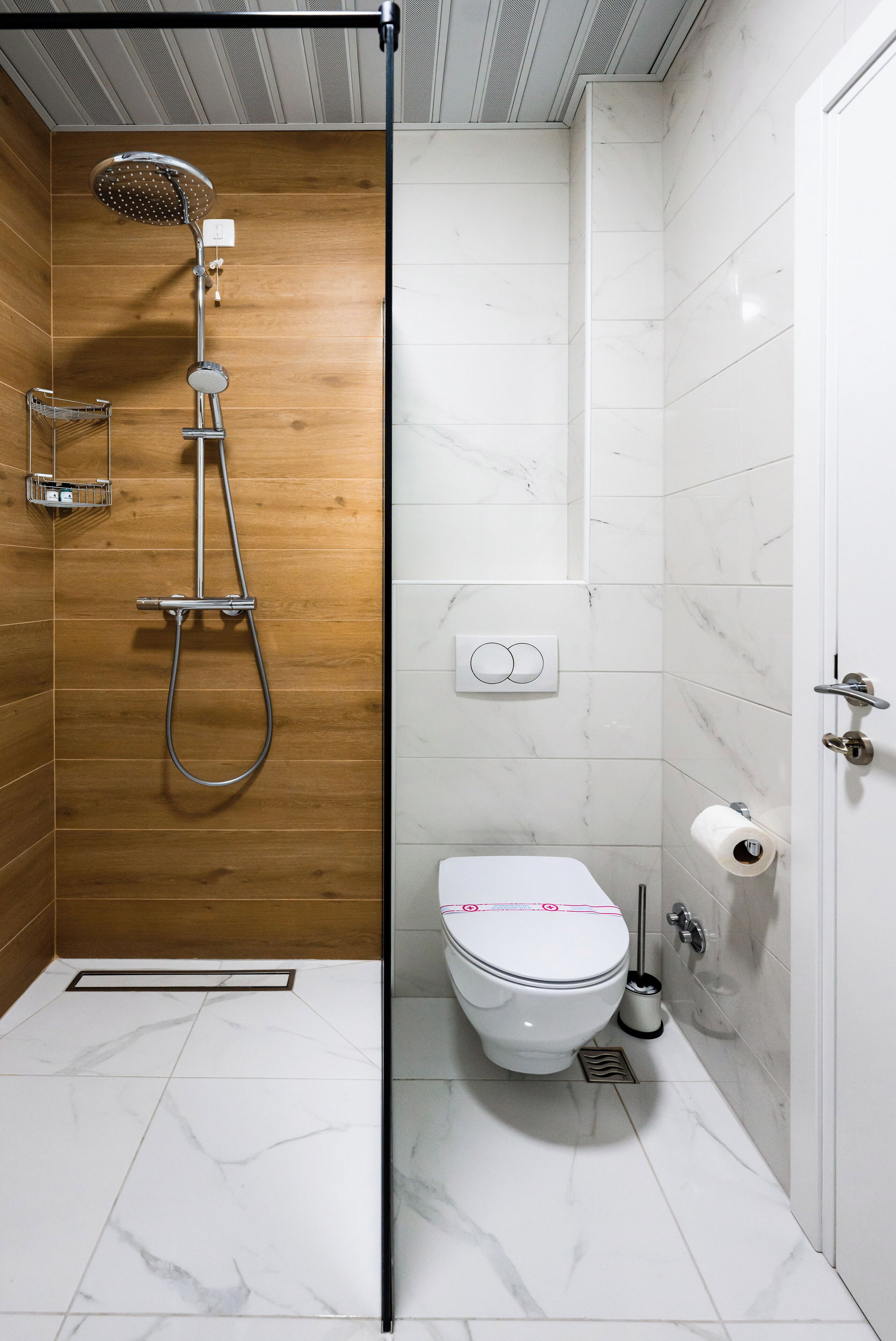 A modern bathroom with a shower, toilet, and a towel rack.