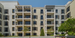 A multi-story residential building with balconies, large windows, and a flat facade.