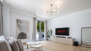A modern living room with a sofa, coffee table, and a TV mounted on the wall.
