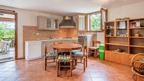 A kitchen with a dining table, chairs, a built-in oven, and a cabinet.