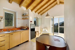 Eine moderne Küche mit Holzschränken, einem Spülbecken und einem Essbereich mit Tisch und Stühlen.