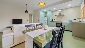 A modern kitchen with a dining area, a flat-screen TV, and a sofa. - Holiday Home 'Carpa' with Mountain View, Wi-Fi and Air Conditioning (Riumar)