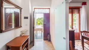 A hallway with a wooden bench, a door leading to an outdoor area, and a view of the outside. - Villa 'Lucia' with Shared Terrace and Wi-Fi (Minturno)