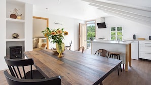 A modern kitchen with a wooden island, white cabinetry, and a large window.