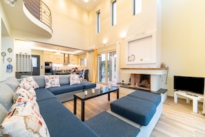 A spacious living area with a sectional sofa, a flat-screen TV, and a fireplace.
