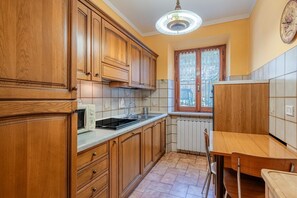 Une cuisine avec des meubles en bois, un four à micro-ondes, un évier et une fenêtre donnant sur un beau paysage.