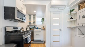 A modern kitchen with a stove, oven, microwave, and white cabinetry. - Hot Tub/1mi to Downtown/3mi to Coronado/KING Bed/Wifi 300mb+/BBQgrill/Harborside (San Diego)