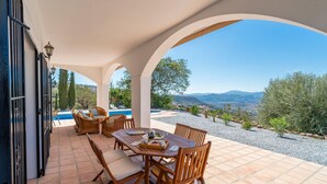A covered outdoor dining area with a view of a swimming pool and mountains. - Villa 'Casa Hyam' with Lake View, Private Pool and Air Conditioning (Alcaucin)