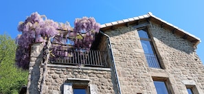 Un bâtiment en pierre doté d’un balcon et d’une grande fenêtre.