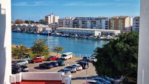 A marina with boats, a parking lot, and buildings in the background.