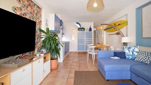 A living room with a television, sofa, and dining area. - Holiday Apartment "Blue Fish" with Shared Pool, Private Terrace & Wi-Fi (Benalmádena)