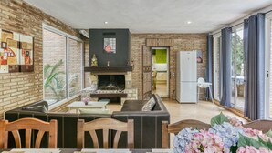Una cocina moderna con pared de ladrillo, chimenea y comedor con mesa y sillas.