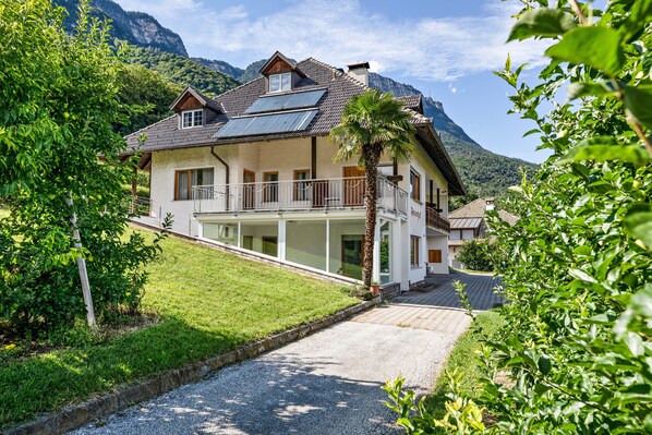 A house with a sloped roof, large windows, and a balcony.