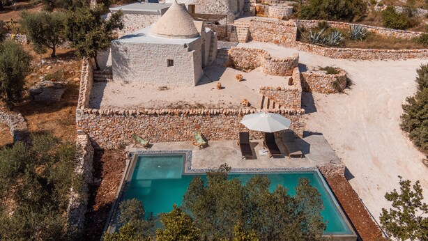 A resort with stone buildings, a swimming pool, and outdoor seating. - Villa 'Trulli Meridiem Con Piscina' with Private Pool, Wi-Fi and Air Conditioning (Ostuni)